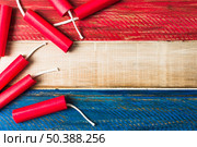 red dynamite firecrackers wooden painted wooden plank background. Стоковое фото, агентство Ingram Publishing / Фотобанк Лори