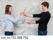 woman accepting yellow tulip flower no cigarette packet offering by handsome man. Стоковое фото, агентство Ingram Publishing / Фотобанк Лори