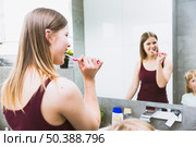 woman brushing teeth near mirror. Стоковое фото, агентство Ingram Publishing / Фотобанк Лори