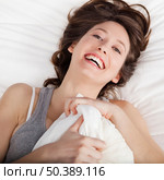 Beautiful and natural young girl on the bed laughing . Стоковое фото, агентство Ingram Publishing / Фотобанк Лори
