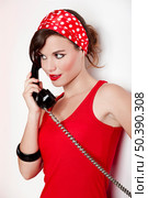 Beautiful and fashion young woman with a pin-up look. posing with a vintage phone. Стоковое фото, агентство Ingram Publishing / Фотобанк Лори