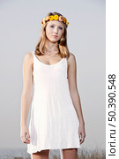Beautiful young woman in a meadow wearing a crown of flowers. Стоковое фото, агентство Ingram Publishing / Фотобанк Лори