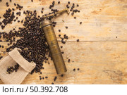 old coffee grinder with coffee beans falling from sack table. Стоковое фото, агентство Ingram Publishing / Фотобанк Лори