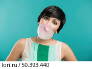 Portrait of a beautiful girl with a bubble gum on the mouth, against a blue background. Стоковое фото, агентство Ingram Publishing / Фотобанк Лори