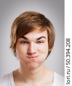 Portrait of a handsome young man, over a gray background. Стоковое фото, агентство Ingram Publishing / Фотобанк Лори