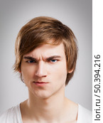 Portrait of a handsome young man, over a gray background. Стоковое фото, агентство Ingram Publishing / Фотобанк Лори