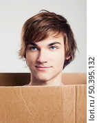Portrait of a handsome young man inside a cardbox. Стоковое фото, агентство Ingram Publishing / Фотобанк Лори