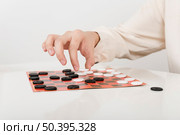 close up person playing checkers. Стоковое фото, агентство Ingram Publishing / Фотобанк Лори