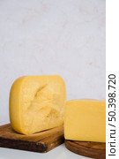 gouda cheese pieces wooden chopping board against marble textured backdrop. Стоковое фото, агентство Ingram Publishing / Фотобанк Лори