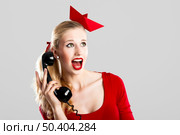 Beautiful fashion woman with a astonished expresion and holding a  vintage phone. Стоковое фото, агентство Ingram Publishing / Фотобанк Лори
