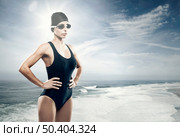 Young athletic swimer woman with googles and swimming cap, with the beach as background. Стоковое фото, агентство Ingram Publishing / Фотобанк Лори