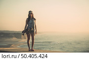 Beautiful and fashion young woman posing at the sunset with a skateboard. Стоковое фото, агентство Ingram Publishing / Фотобанк Лори
