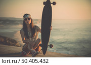 Beautiful fashion skater girl posing with  a skate board. Стоковое фото, агентство Ingram Publishing / Фотобанк Лори