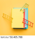 bright ladders stack colorful blank books yellow background. Стоковое фото, агентство Ingram Publishing / Фотобанк Лори