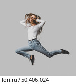 ecstatic woman with headphones jumping air. Стоковое фото, агентство Ingram Publishing / Фотобанк Лори