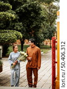 front view man woman temple with incense bouquet flowers. Стоковое фото, агентство Ingram Publishing / Фотобанк Лори