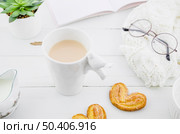 palmiers puff pastry cookie with porcelain white tea cup wooden desk. Стоковое фото, агентство Ingram Publishing / Фотобанк Лори