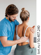 side view male osteopathic therapist checking female patient s scapula movement. Стоковое фото, агентство Ingram Publishing / Фотобанк Лори