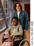 student helping colleague wheelchair. Стоковое фото, агентство Ingram Publishing / Фотобанк Лори