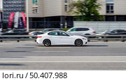 Alfa Romeo Giulia on the road in motion. Fast speed drive on city road. Side view of moving white car on the street. Редакционное фото, фотограф Константин Григорьев / Фотобанк Лори