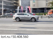 Car Genesis GV80 moving on the street. SUV vehicle driving along sunny street in city with blurred background. Редакционное фото, фотограф Константин Григорьев / Фотобанк Лори