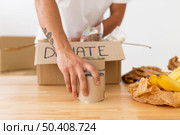 volunteer placing cans with food boxes close up. Стоковое фото, агентство Ingram Publishing / Фотобанк Лори
