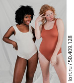 fair dark skinned young women standing against grey background. Стоковое фото, агентство Ingram Publishing / Фотобанк Лори