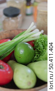Vertical slow-motion footage of plate with broccoli, green onion, red radish, lettuce, pomegranate, tomatoes and avocado, next to jars of spices and cereals. Стоковое видео, видеограф Vladimir Drozdin / Фотобанк Лори