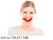 Beautiful girl biting a red chilli pepper, isolated over a white background. Стоковое фото, агентство Ingram Publishing / Фотобанк Лори