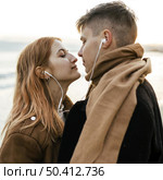 couple listening music earphones together beach winter. Стоковое фото, агентство Ingram Publishing / Фотобанк Лори