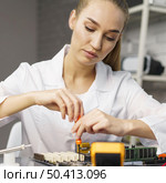 front view female technician with electronics board. Стоковое фото, агентство Ingram Publishing / Фотобанк Лори