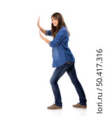 Beautiful woman push something over a white background. Woman push something. Стоковое фото, агентство Ingram Publishing / Фотобанк Лори