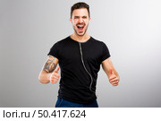 Beautiful and happy latin man listen music with thumbs up. Стоковое фото, агентство Ingram Publishing / Фотобанк Лори