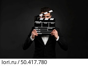 Handsome young man wearing a tuxedo and holding a clapboard. Стоковое фото, агентство Ingram Publishing / Фотобанк Лори