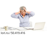 Stressed elderly woman working in the office with a laptop. Стоковое фото, агентство Ingram Publishing / Фотобанк Лори
