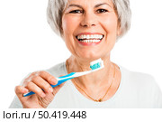 Portrait of a happy old woman brushing her teeth. Стоковое фото, агентство Ingram Publishing / Фотобанк Лори