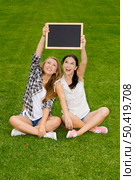 Tennage students sitting on the grass and holding a chalkboard. Стоковое фото, агентство Ingram Publishing / Фотобанк Лори