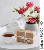 bouquet roses vase wrapped gift cup tea. Стоковое фото, агентство Ingram Publishing / Фотобанк Лори