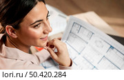 close up smiley woman with plans. Стоковое фото, агентство Ingram Publishing / Фотобанк Лори