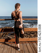 back view athletic woman stretching by beach. Стоковое фото, агентство Ingram Publishing / Фотобанк Лори