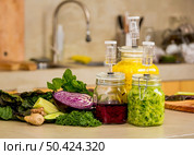 Preparing fermented preserved vegetables. Jars of cabbage kimchi and sauerkraut sour cabbage. . Стоковое фото, агентство Ingram Publishing / Фотобанк Лори