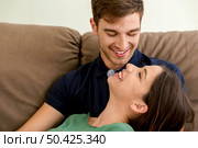 Young couple sitting on the sofa and dating. Стоковое фото, агентство Ingram Publishing / Фотобанк Лори