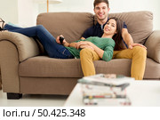 Young couple sitting on the sofa and watching movies. Стоковое фото, агентство Ingram Publishing / Фотобанк Лори