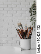 arrangement with brushes pens cup. Стоковое фото, агентство Ingram Publishing / Фотобанк Лори