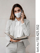 elegant businesswoman with mask talking phone. Стоковое фото, агентство Ingram Publishing / Фотобанк Лори