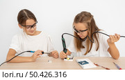 girls with protective glasses doing science experiments together. Стоковое фото, агентство Ingram Publishing / Фотобанк Лори