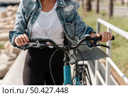 woman holding bike by handlebar grips. Стоковое фото, агентство Ingram Publishing / Фотобанк Лори