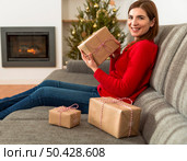 Beautiful happy woman at home holding Christmas presents. Стоковое фото, агентство Ingram Publishing / Фотобанк Лори