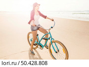 An attractive young woman riding her bicycle on the beach. Стоковое фото, агентство Ingram Publishing / Фотобанк Лори