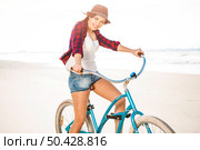 An attractive young woman riding her bicycle on the beach. Стоковое фото, агентство Ingram Publishing / Фотобанк Лори
